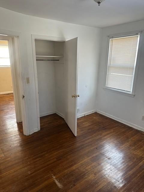 unfurnished bedroom with a closet and dark hardwood / wood-style floors