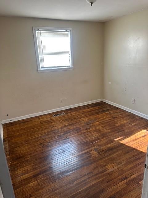 unfurnished room with dark wood-type flooring