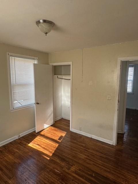 unfurnished bedroom featuring dark hardwood / wood-style floors and a closet