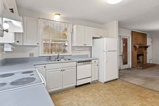 kitchen featuring white cabinetry, a brick fireplace, sink, and white appliances