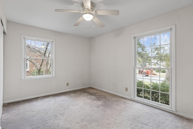 carpeted spare room featuring ceiling fan