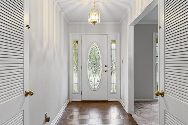 entryway with dark hardwood / wood-style flooring, crown molding, and a chandelier