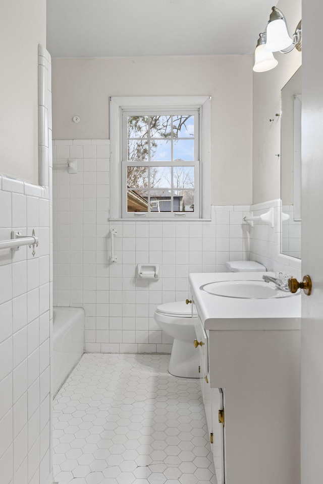 bathroom with vanity, tile walls, tile patterned floors, and toilet