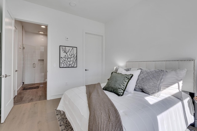 bedroom with light wood-type flooring and ensuite bath