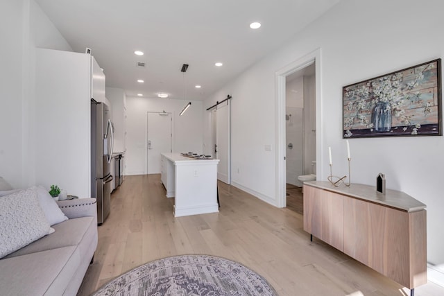 interior space featuring a barn door and light hardwood / wood-style flooring