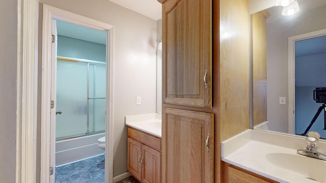 full bathroom featuring vanity, shower / bath combination with glass door, and toilet