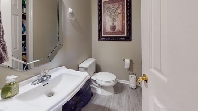 bathroom with sink, hardwood / wood-style flooring, and toilet