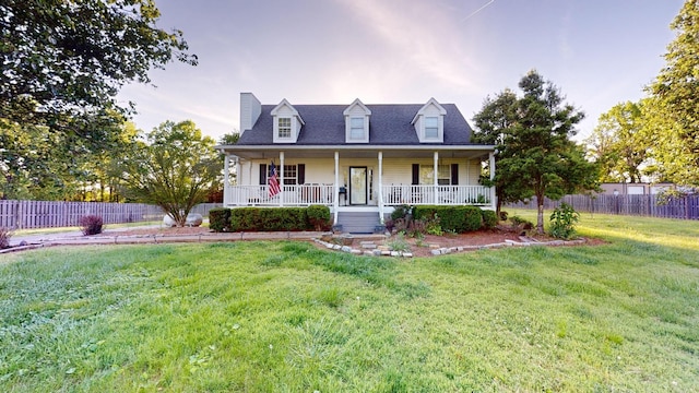 cape cod house with covered porch and a front yard