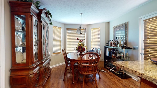 dining area featuring dark wood-type flooring and a textured ceiling