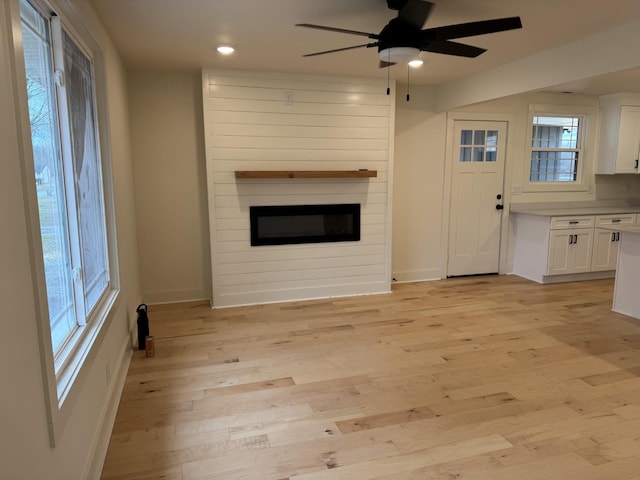 unfurnished living room featuring light hardwood / wood-style flooring and ceiling fan