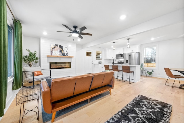 living room featuring ceiling fan and light wood-type flooring