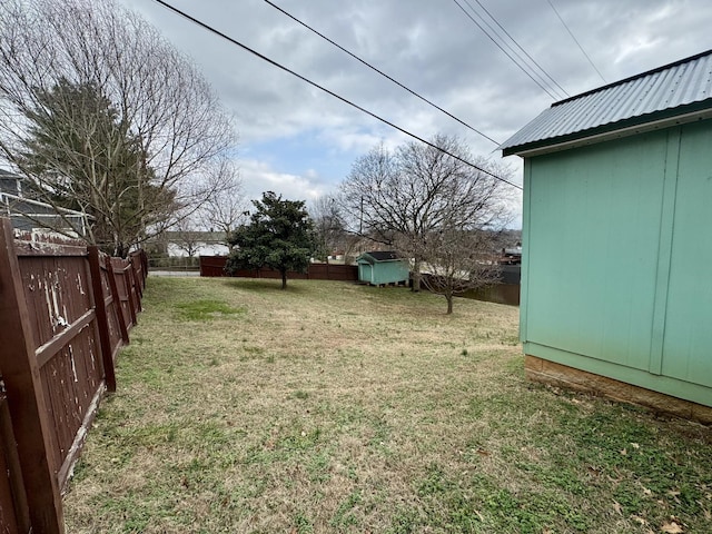 view of yard featuring a fenced backyard, an outdoor structure, and a storage unit