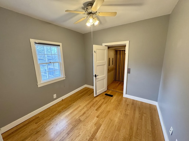 unfurnished bedroom with light wood-type flooring, visible vents, baseboards, and ceiling fan