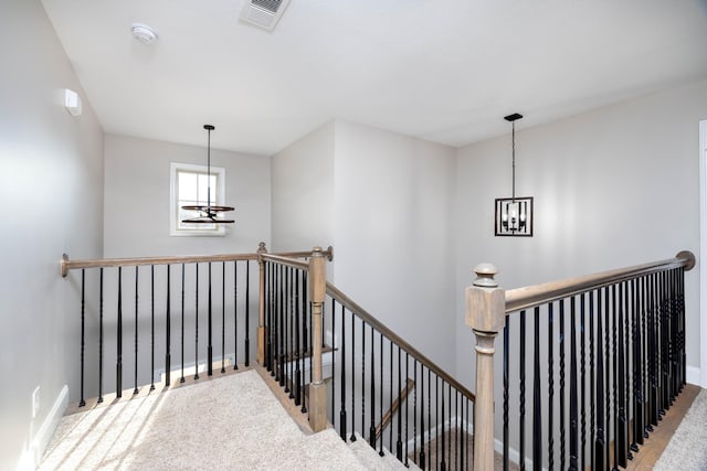 staircase featuring an inviting chandelier and carpet floors