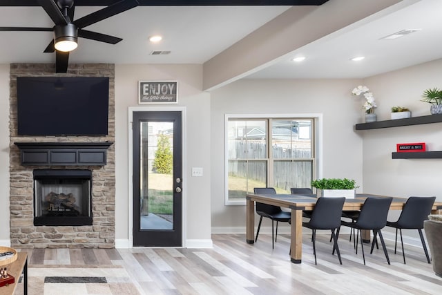 interior space with ceiling fan, a fireplace, and light hardwood / wood-style flooring