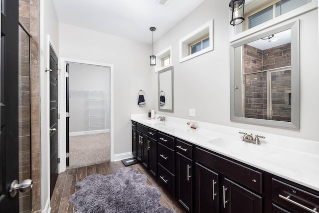 bathroom with vanity, wood-type flooring, and a shower with door