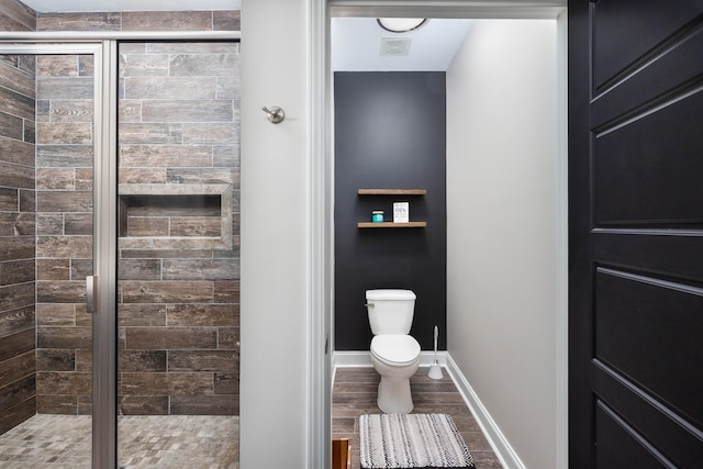 bathroom featuring hardwood / wood-style floors, toilet, and walk in shower