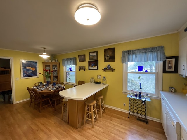 bar with light hardwood / wood-style flooring and ornamental molding