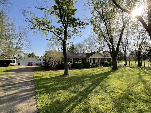 ranch-style house with a garage, an outdoor structure, a front yard, and covered porch