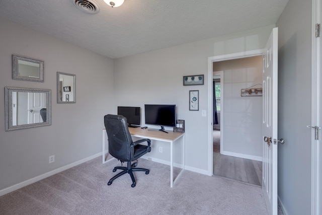 carpeted office space featuring a textured ceiling