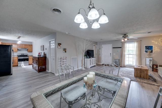 living room featuring ceiling fan, light hardwood / wood-style floors, and a textured ceiling