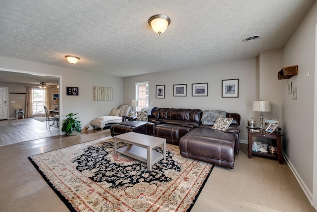 living room with ceiling fan, a healthy amount of sunlight, and a textured ceiling