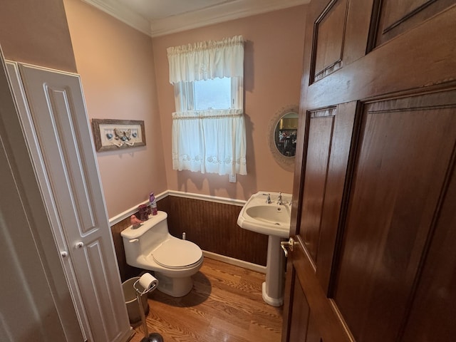 bathroom with ornamental molding, toilet, and hardwood / wood-style floors