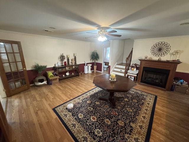 living room with hardwood / wood-style flooring, ornamental molding, and ceiling fan