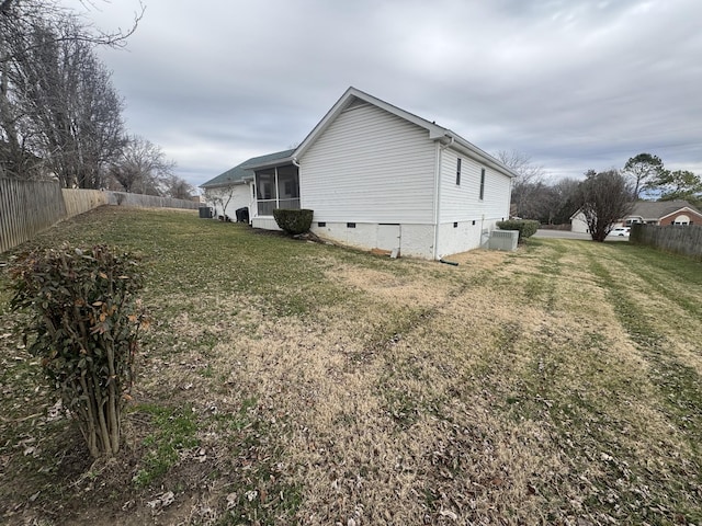 view of property exterior featuring a sunroom, a yard, and central air condition unit