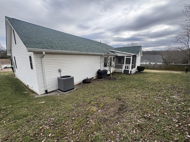 rear view of house with a sunroom, a yard, and cooling unit