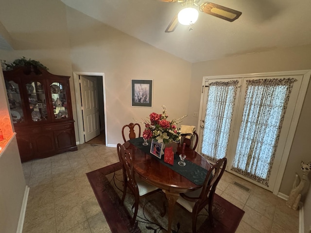 tiled dining space featuring lofted ceiling and ceiling fan