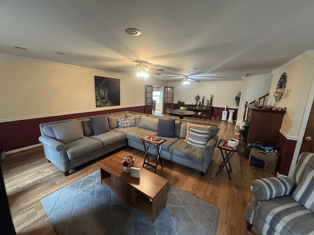 living room featuring hardwood / wood-style flooring, ceiling fan, and crown molding