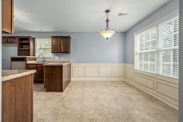 kitchen featuring sink, decorative light fixtures, dark brown cabinets, and stainless steel dishwasher