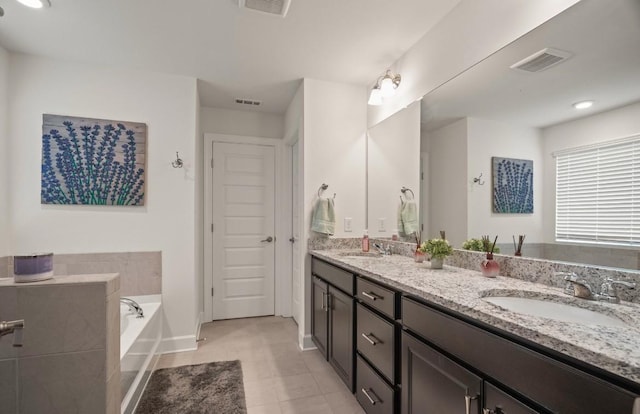 bathroom featuring vanity, a washtub, and tile patterned floors