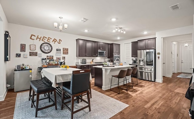 dining area with an inviting chandelier, sink, and dark hardwood / wood-style flooring