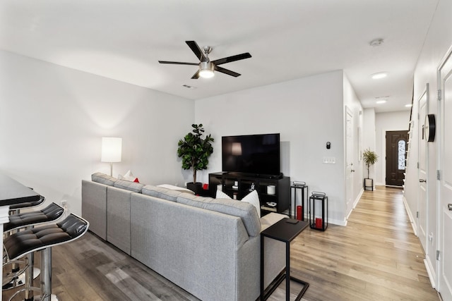 living room with ceiling fan and light hardwood / wood-style flooring