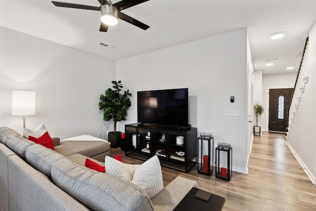 living room with light hardwood / wood-style floors and ceiling fan