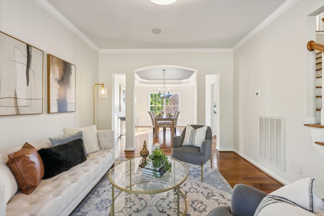 living room featuring wood-type flooring, ornamental molding, and a chandelier