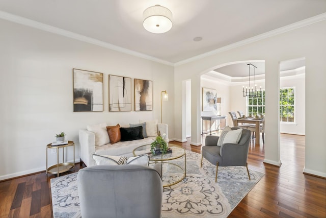 living room featuring ornamental molding, dark hardwood / wood-style flooring, and a chandelier