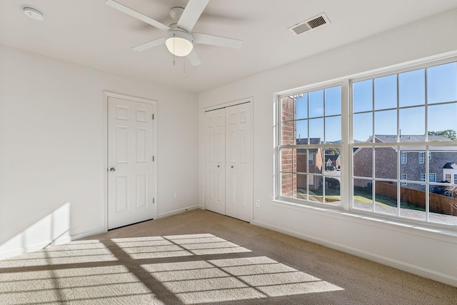 empty room featuring light colored carpet and ceiling fan