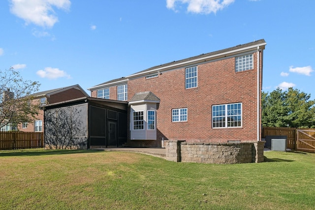 back of house with a sunroom, central air condition unit, and a lawn