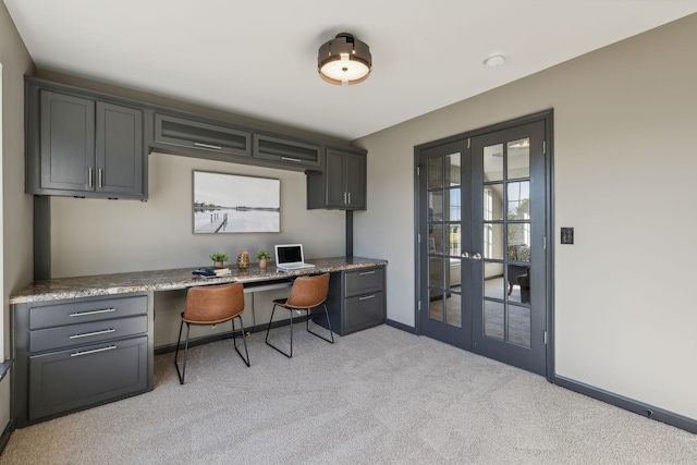 carpeted office featuring built in desk and french doors