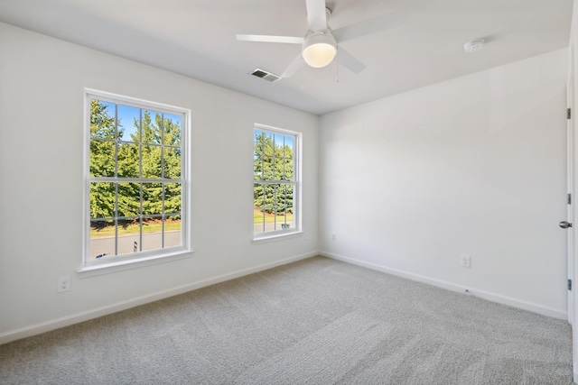 empty room with ceiling fan, carpet, and a wealth of natural light