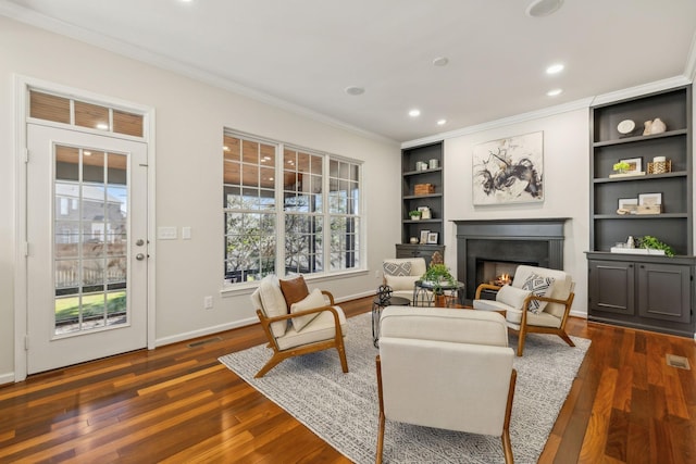 living area with dark wood-type flooring and ornamental molding