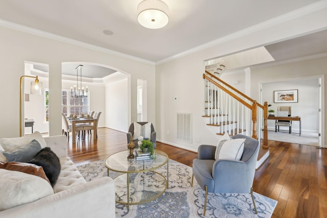 living room featuring ornamental molding, dark wood-type flooring, and a notable chandelier