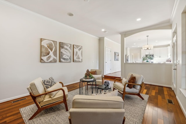 living area featuring ornamental molding and dark hardwood / wood-style floors