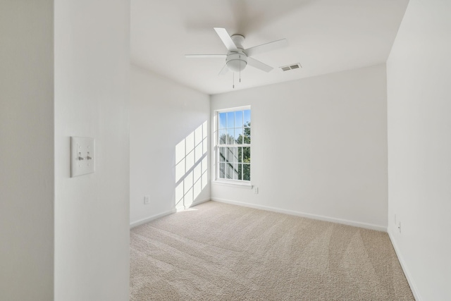 spare room featuring light colored carpet and ceiling fan