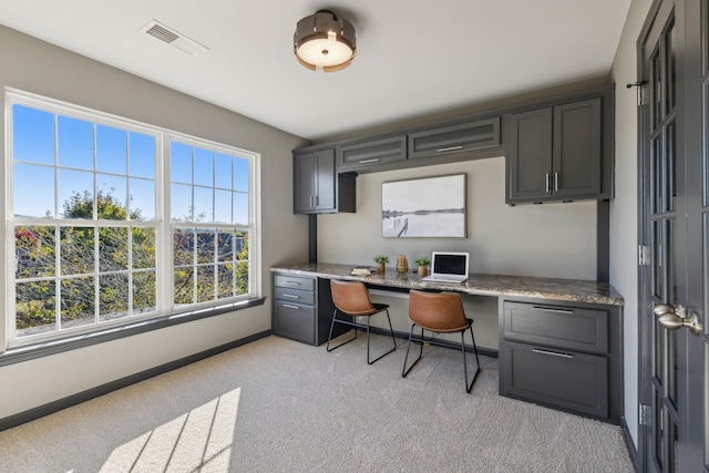 office space featuring light carpet and built in desk