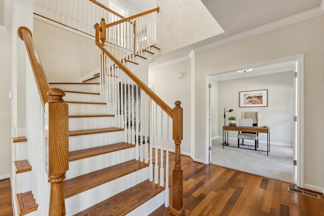 stairway featuring crown molding and wood-type flooring