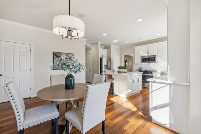 dining space featuring a notable chandelier, ornamental molding, and light wood-type flooring